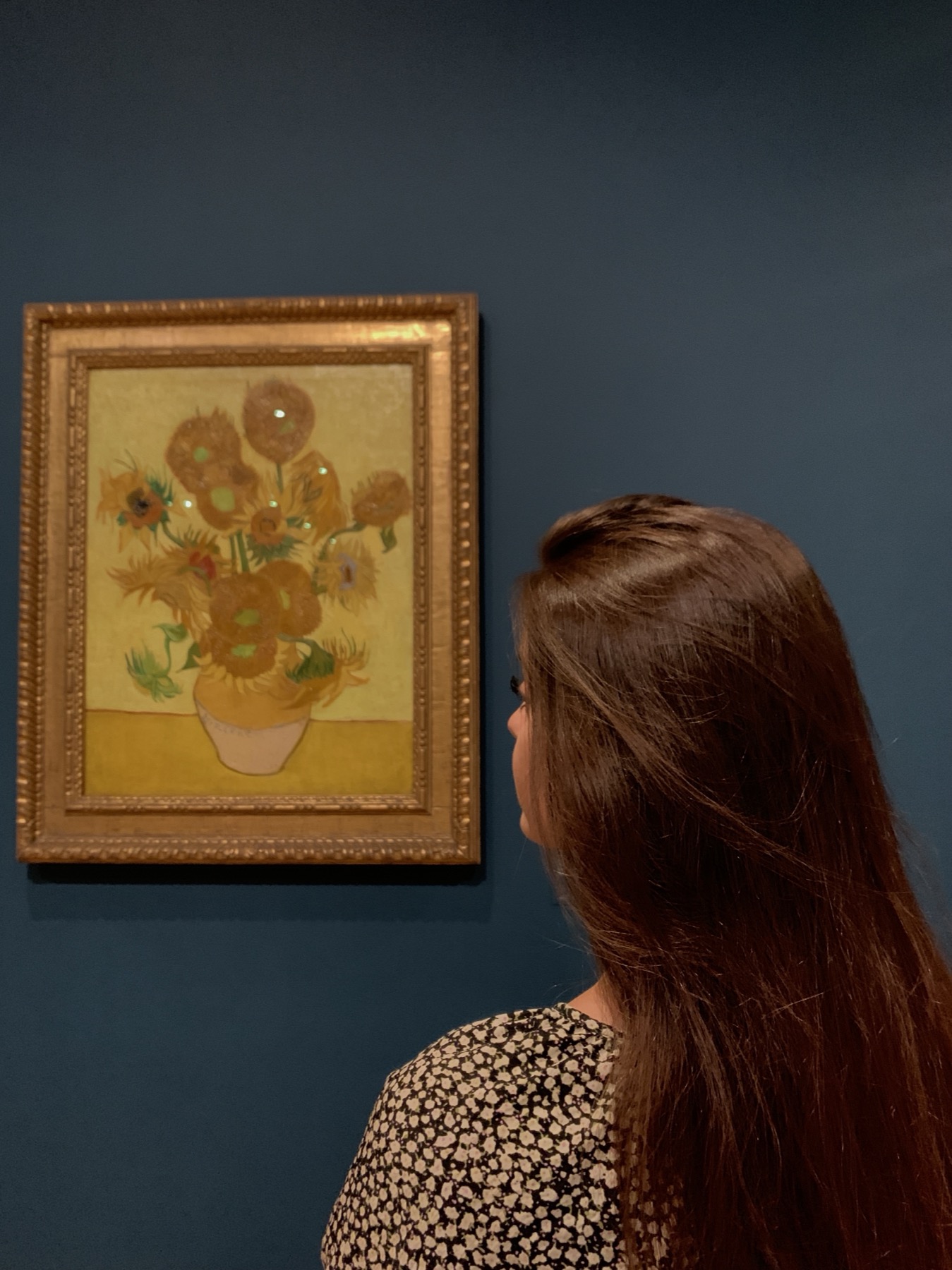 Esma viewing Van Gogh's Sunflowers in an art museum